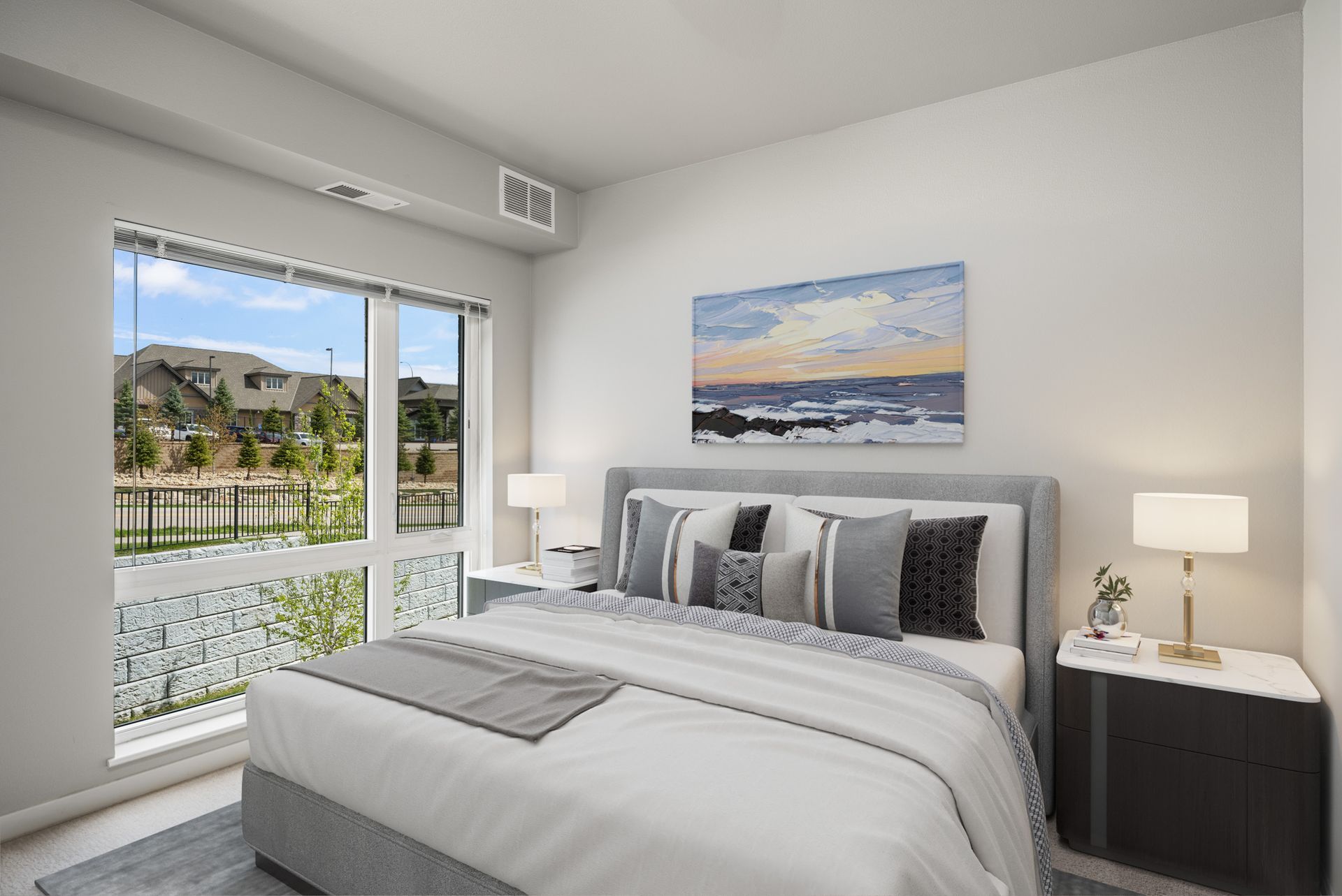 Bedroom with bed, nightstands, and window overlooking a waterside landscape.