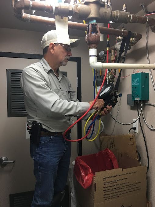 A man is working on a pipe in a room