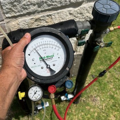 A person is holding a pressure gauge in their hand.