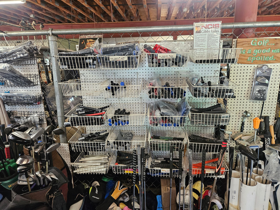 Hardware store aisle with hanging hand tools, pliers, and screwdrivers on display racks