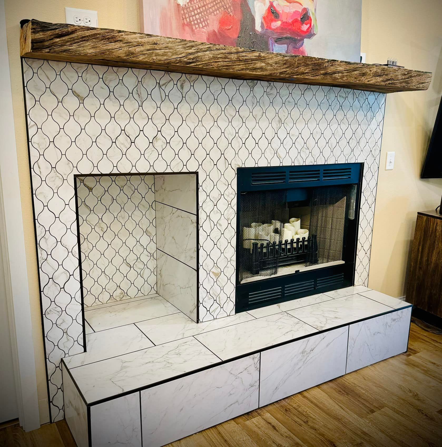A fireplace with white tiles and a wooden mantle in a living room.