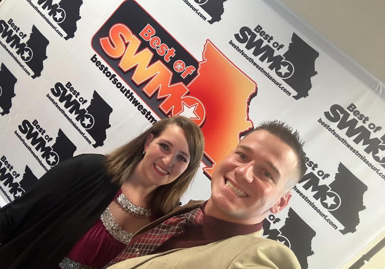 Two people smiling in front of a