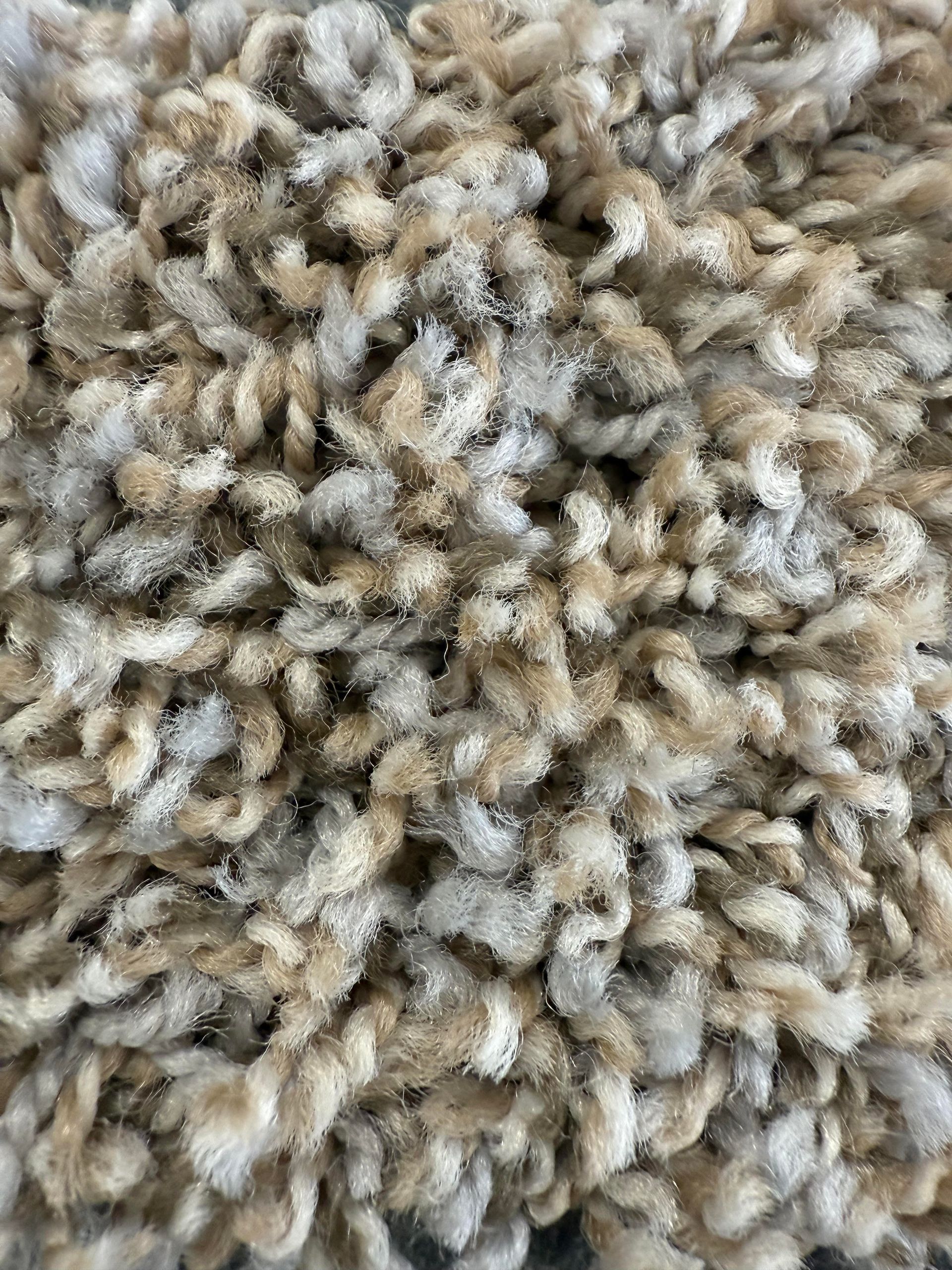 Close-up of a beige and tan looped carpet.