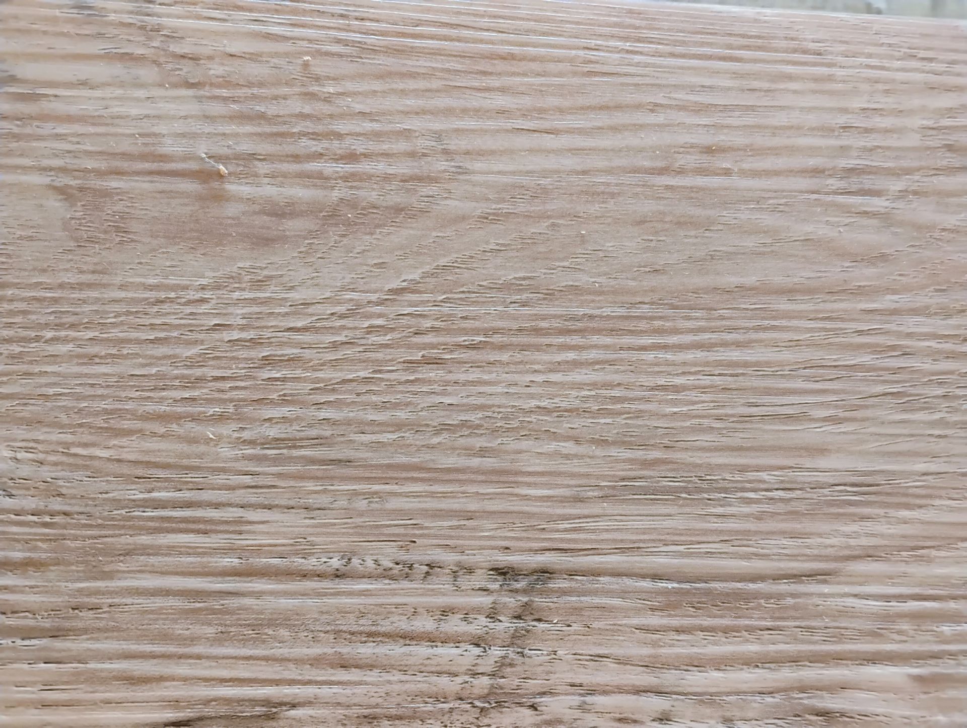 Assorted wooden sample squares in various shades of brown, gray, and cream, displayed on a dark surface.