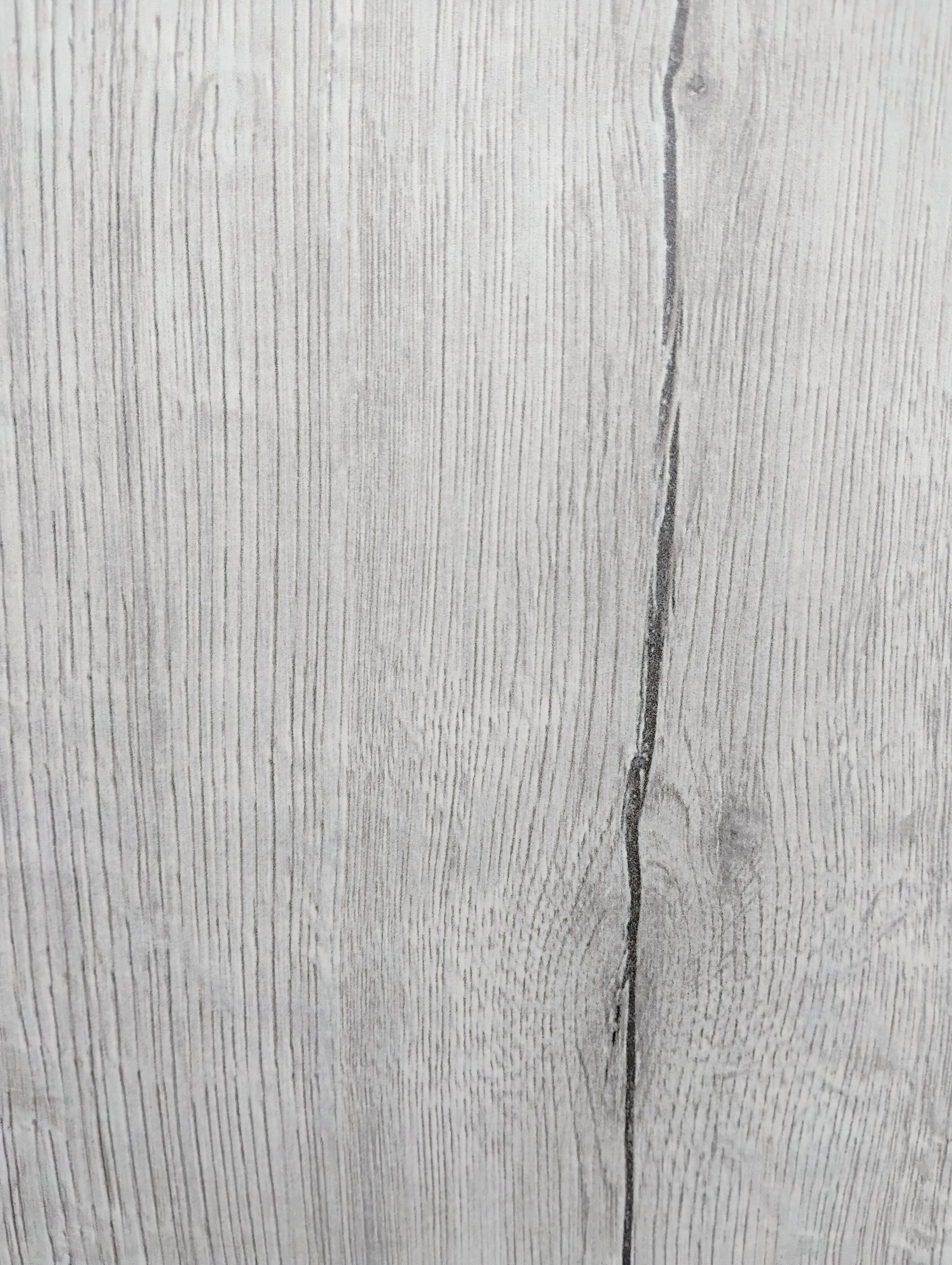 Assorted wooden sample squares in various shades of brown, gray, and cream, displayed on a dark surface.