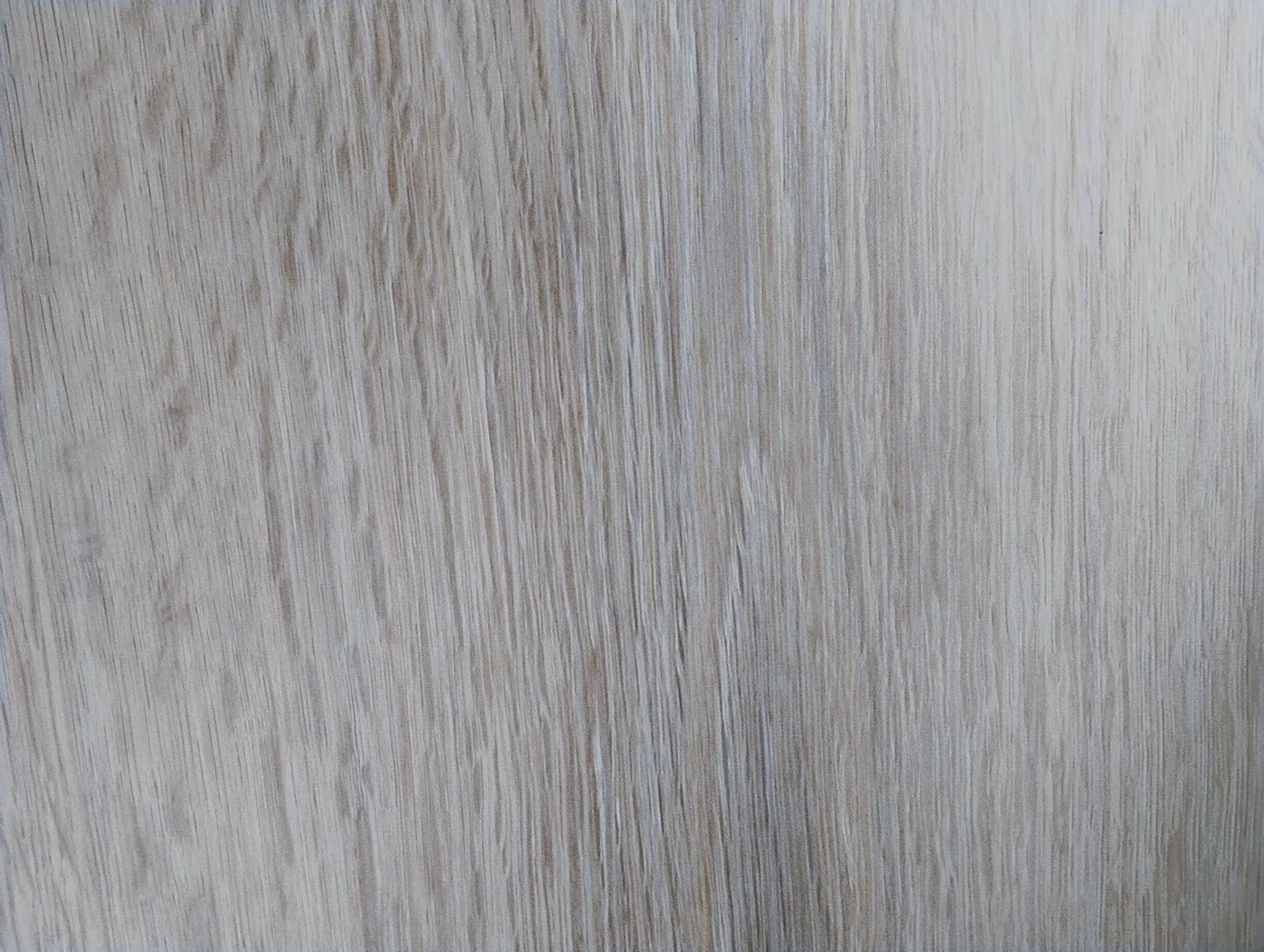 Assorted wooden sample squares in various shades of brown, gray, and cream, displayed on a dark surface.