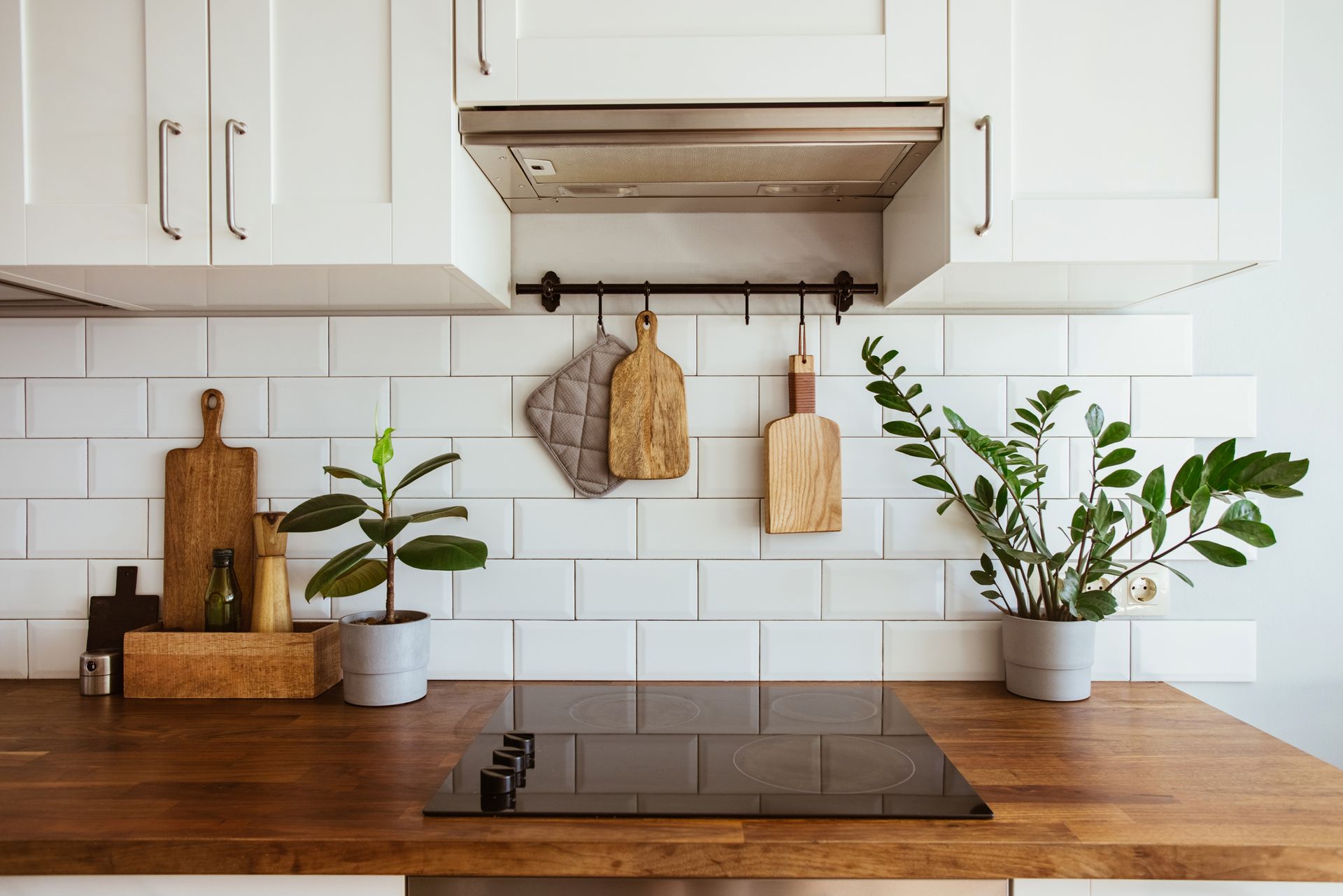 A kitchen with white cabinets and a wooden counter top.