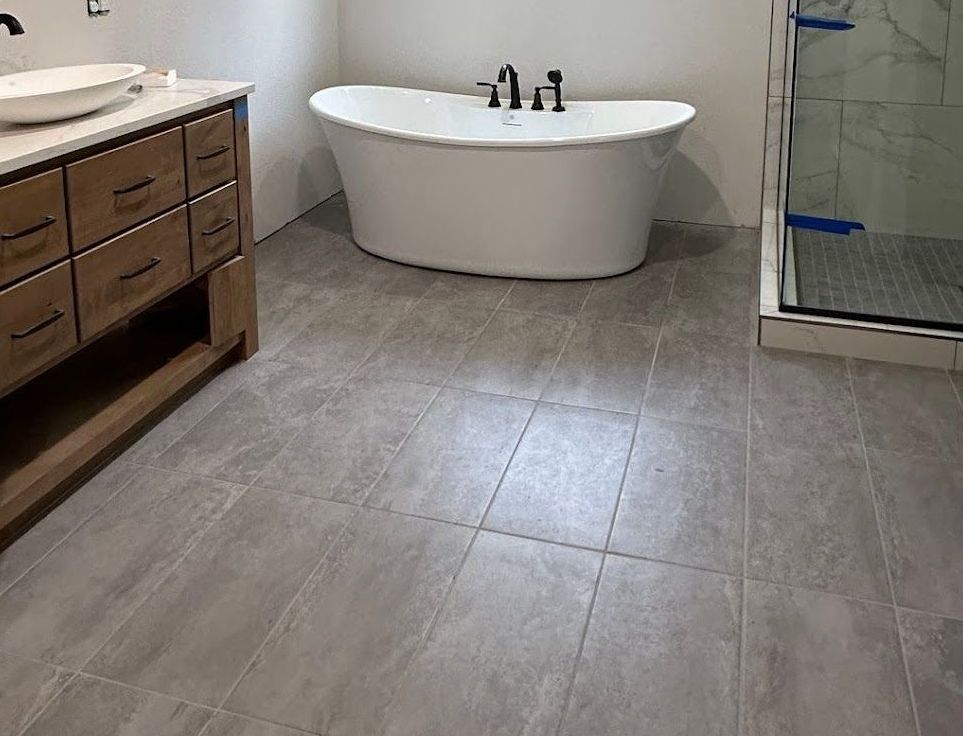 A bathroom with a bathtub , sink , and shower.