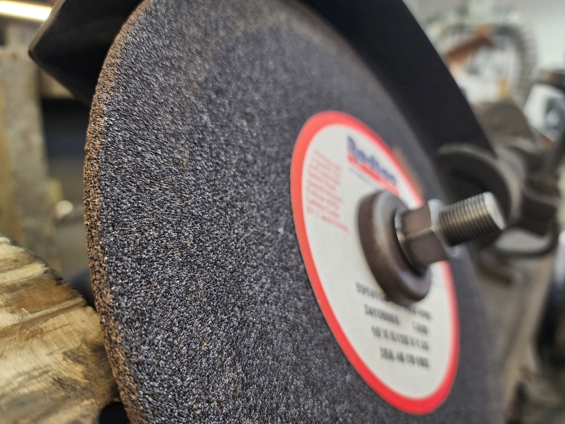 A close up of a grinding wheel on a machine