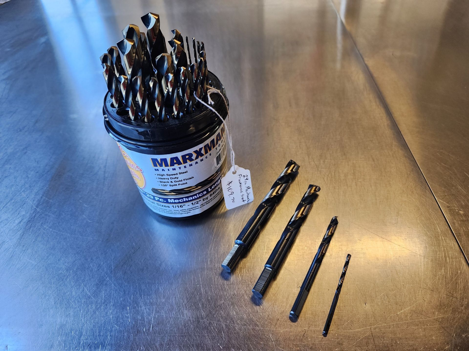 A bucket of drill bits is sitting on a stainless steel table.