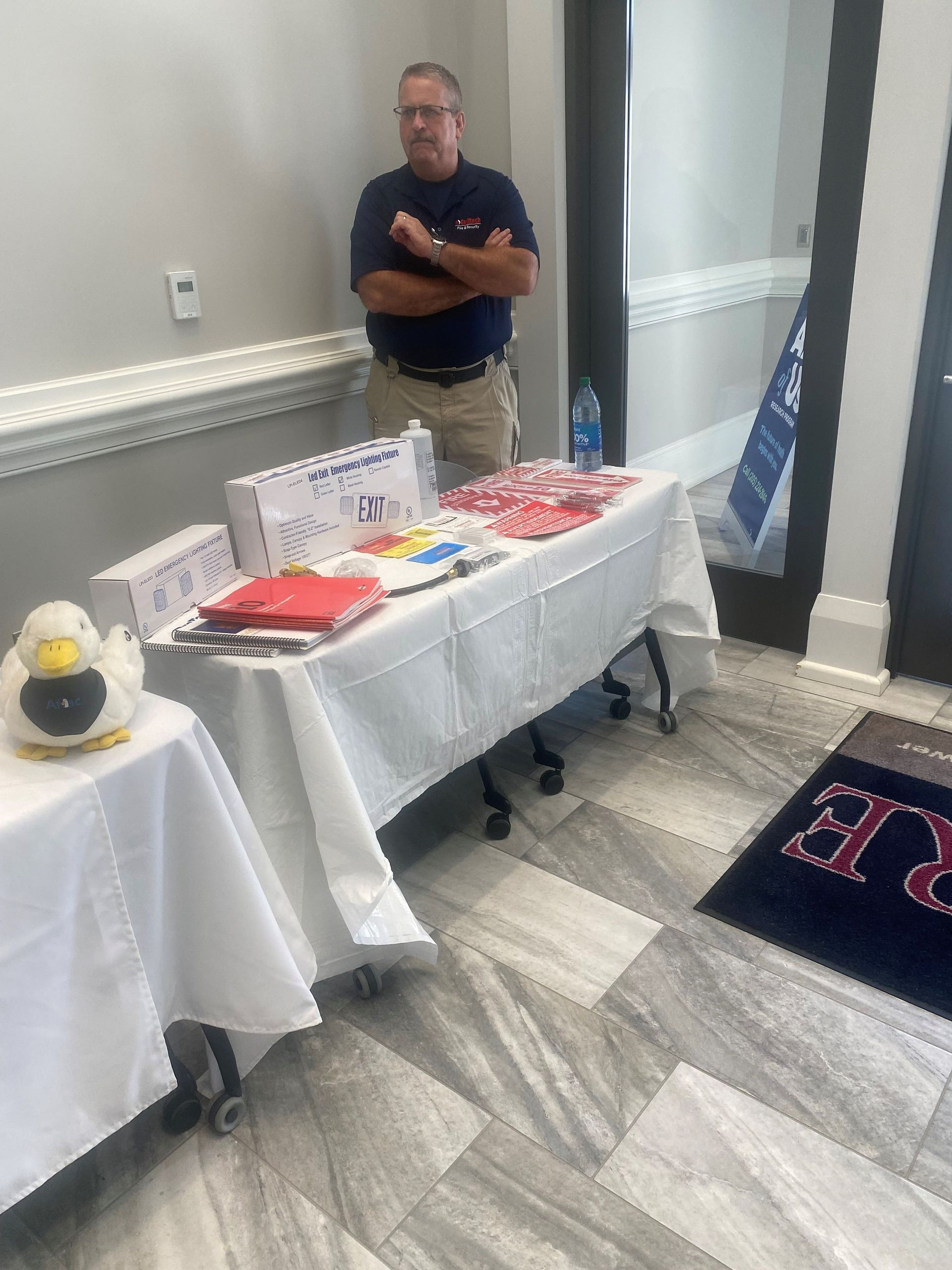 A man is standing in front of a table with a duck on it.