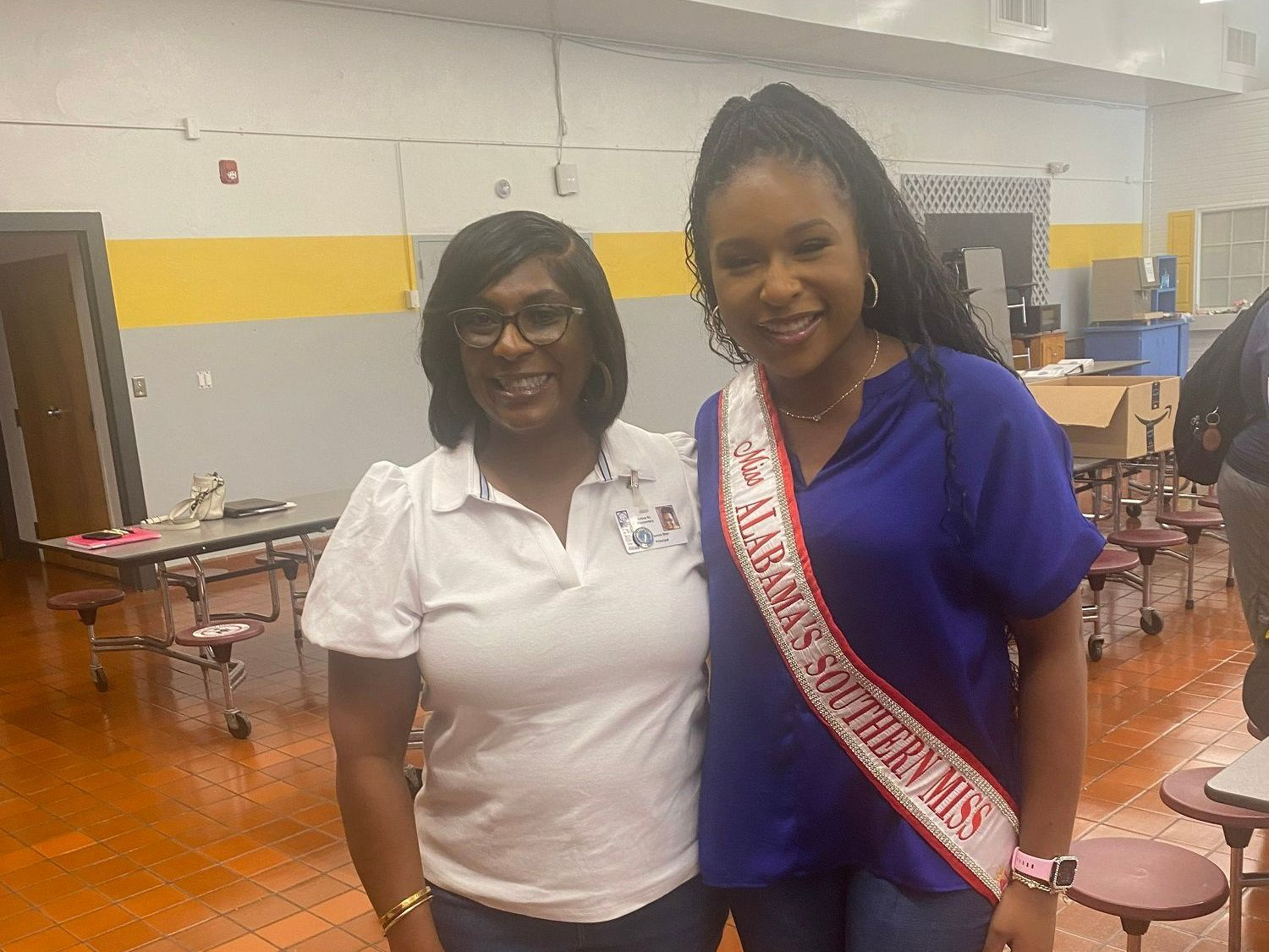 Two women are posing for a picture together in a room.