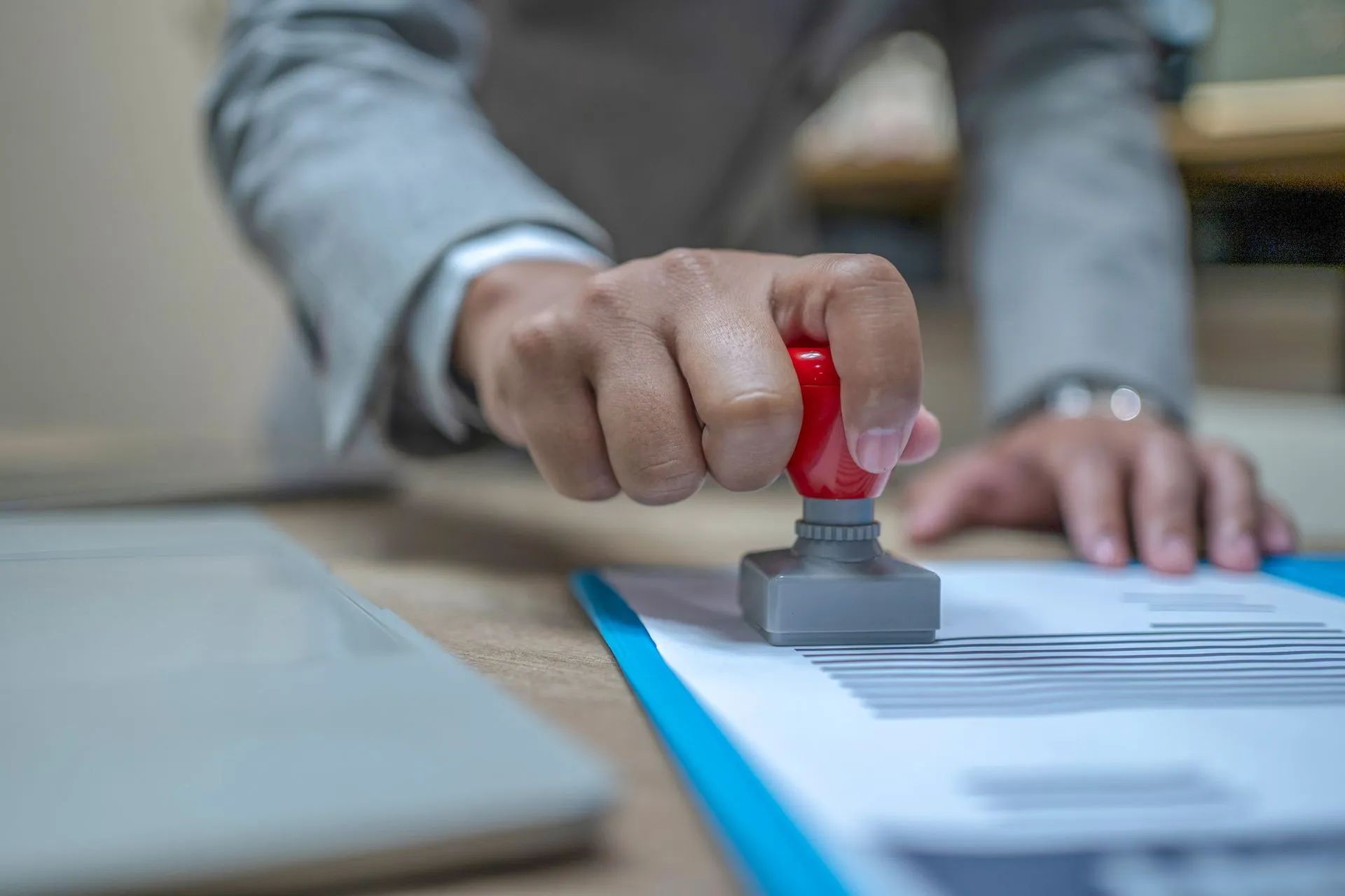 A person is stamping a document on a clipboard.