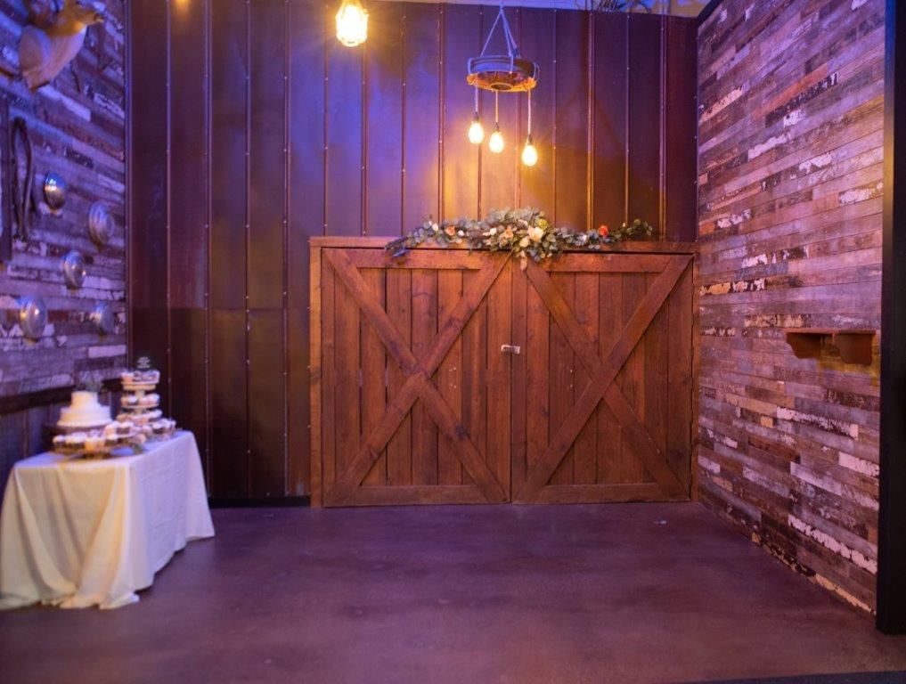 There is a table with a cake on it in front of a wooden door.