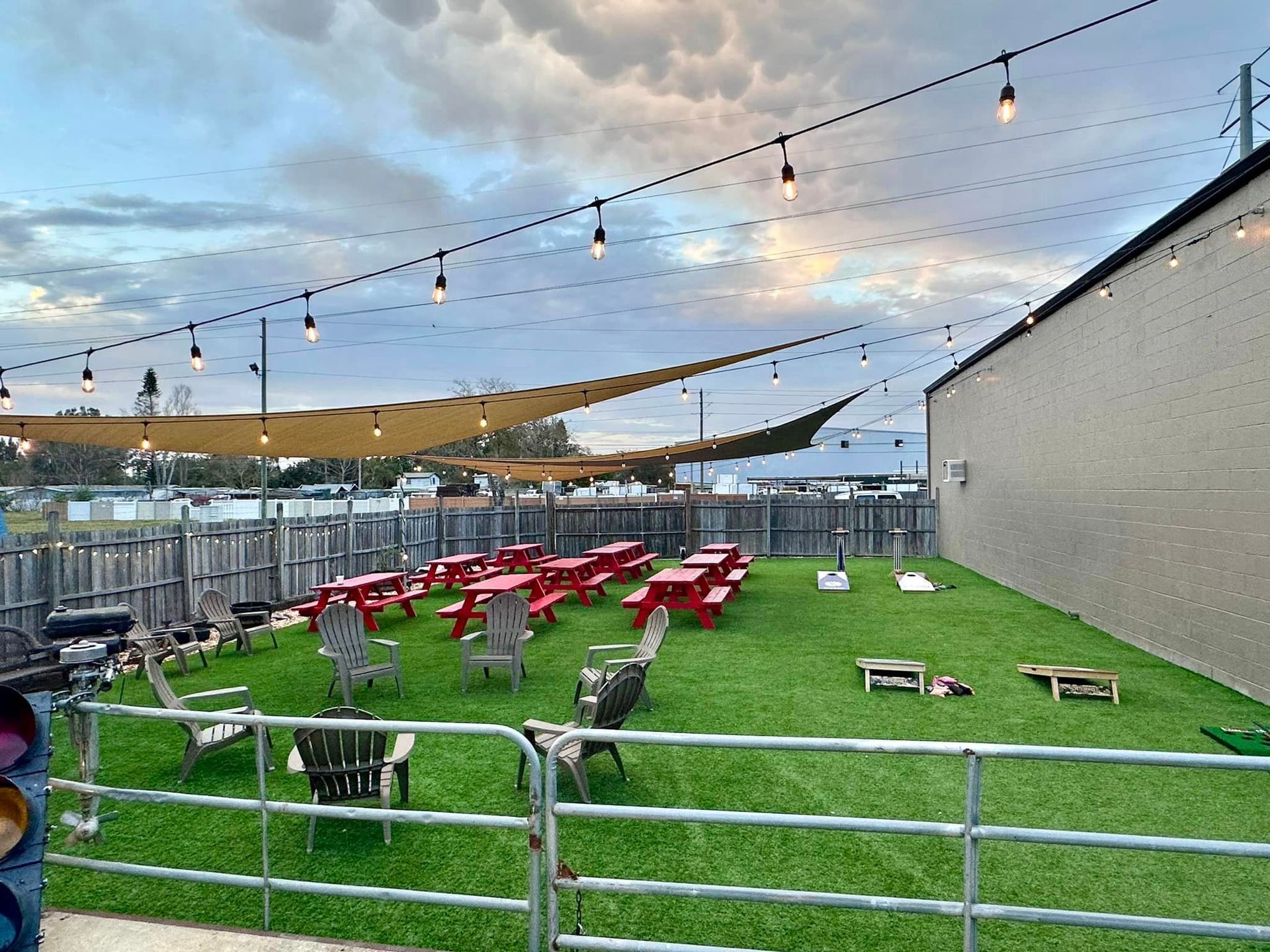 There are many picnic tables and chairs in the grass.