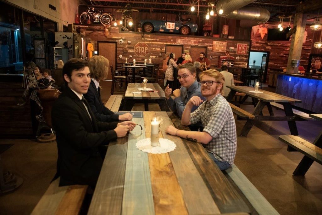 A group of people are sitting at a picnic table in a restaurant.