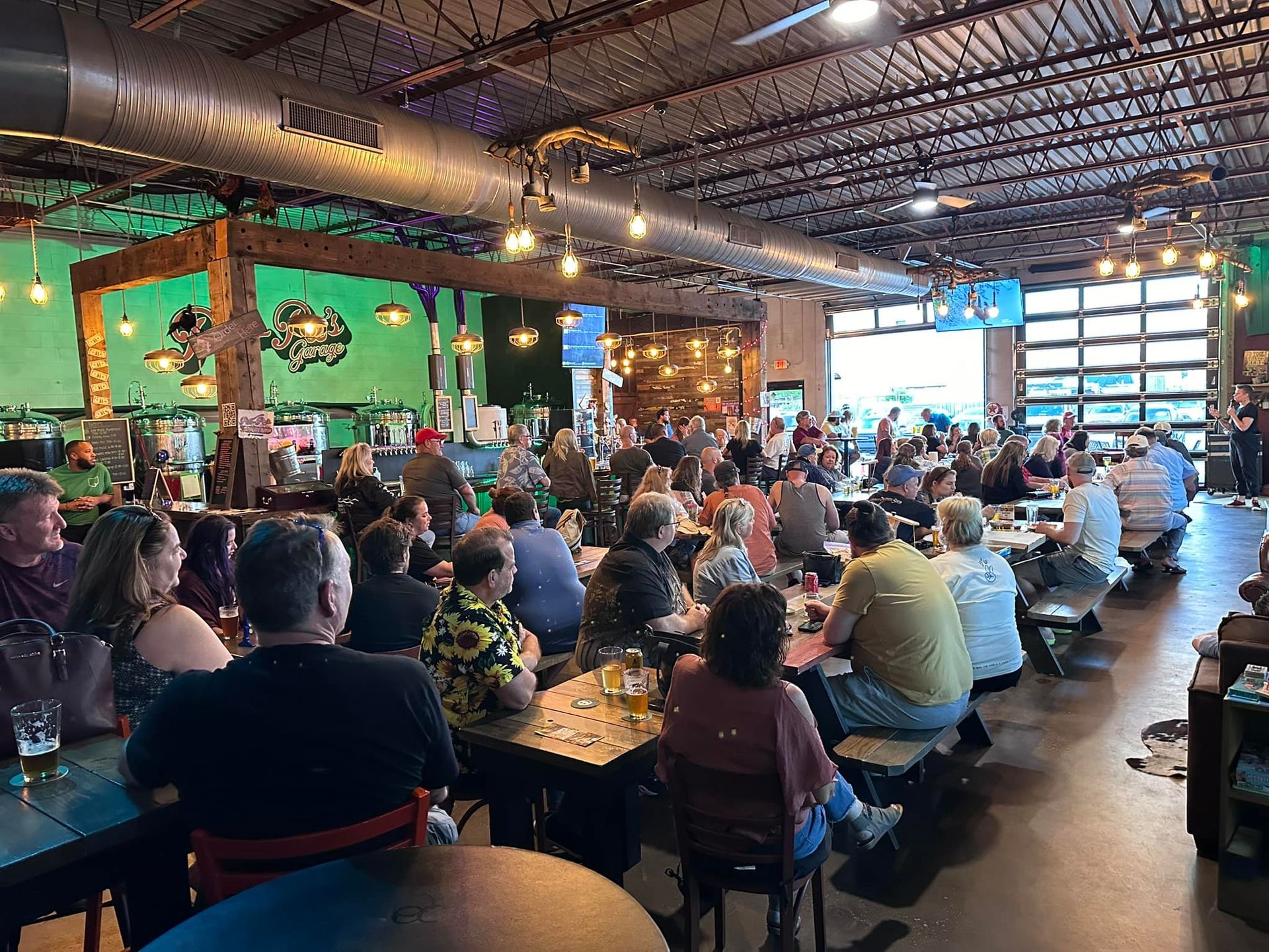 A large group of people are sitting at tables in a restaurant.