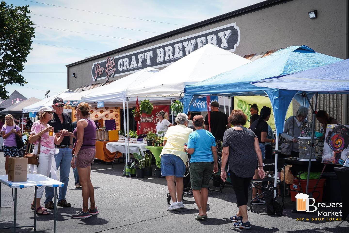 A group of people are standing in front of a craft brewery