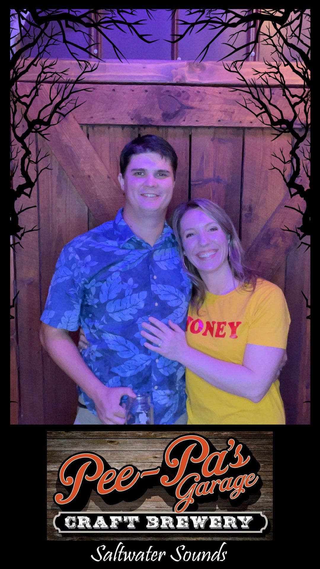 A man and a woman are posing for a picture in front of a wooden wall.