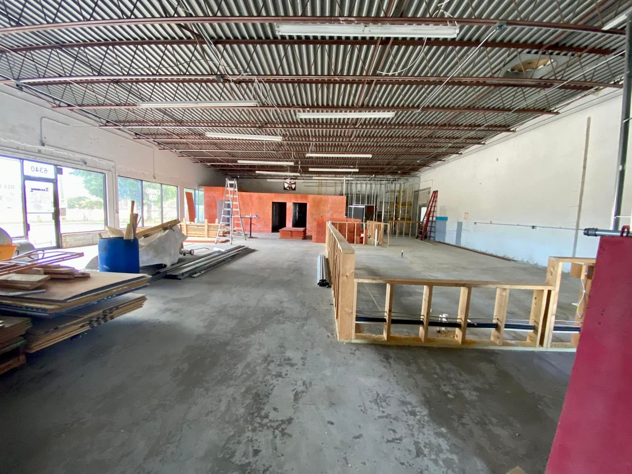A large warehouse with a lot of windows and a wooden structure in the middle.