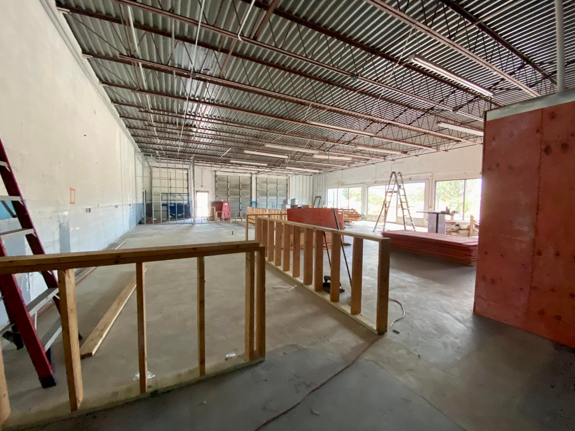 A large building under construction with a wooden railing and a ladder.