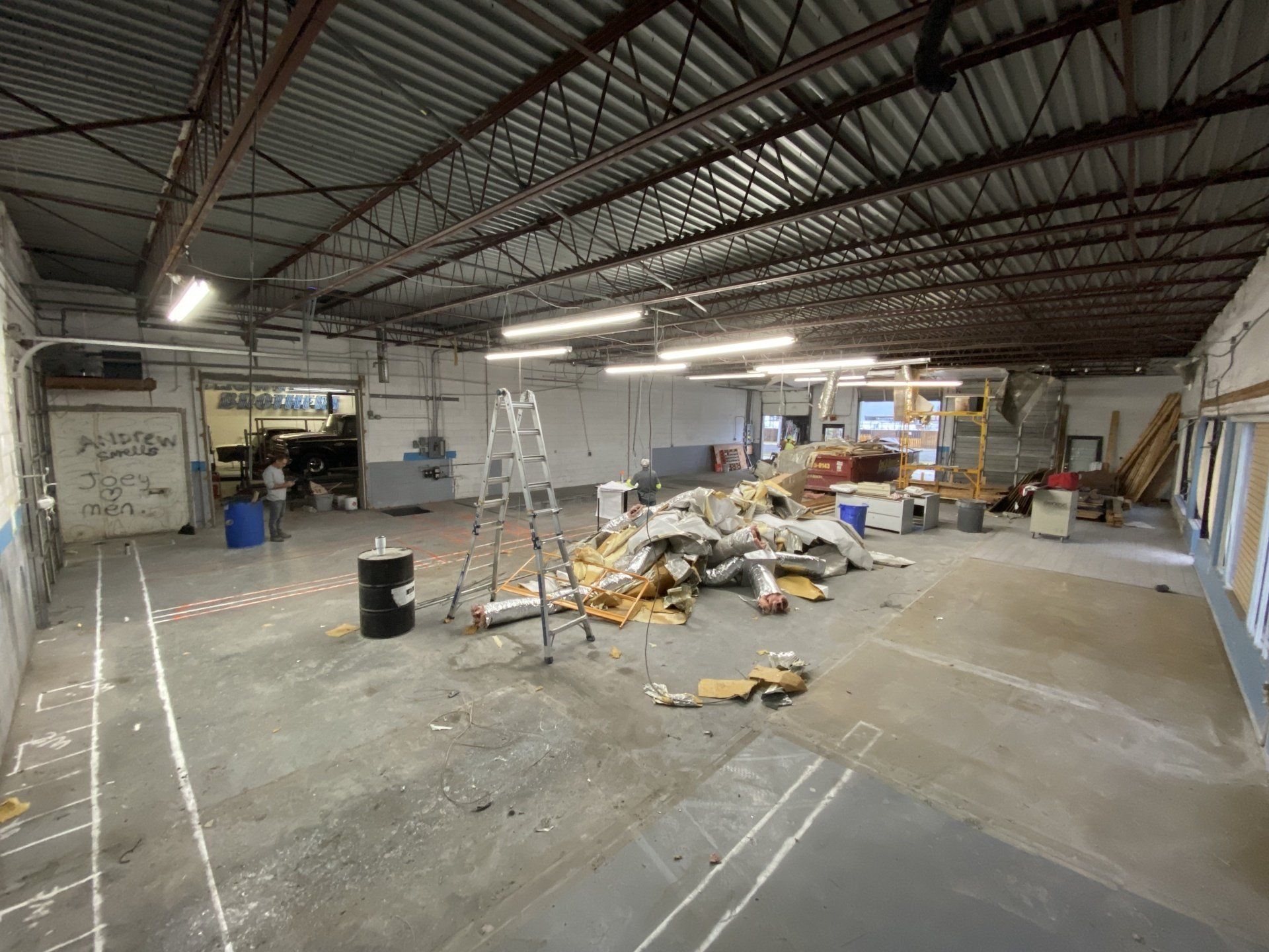 A large empty warehouse with a lot of junk in it.