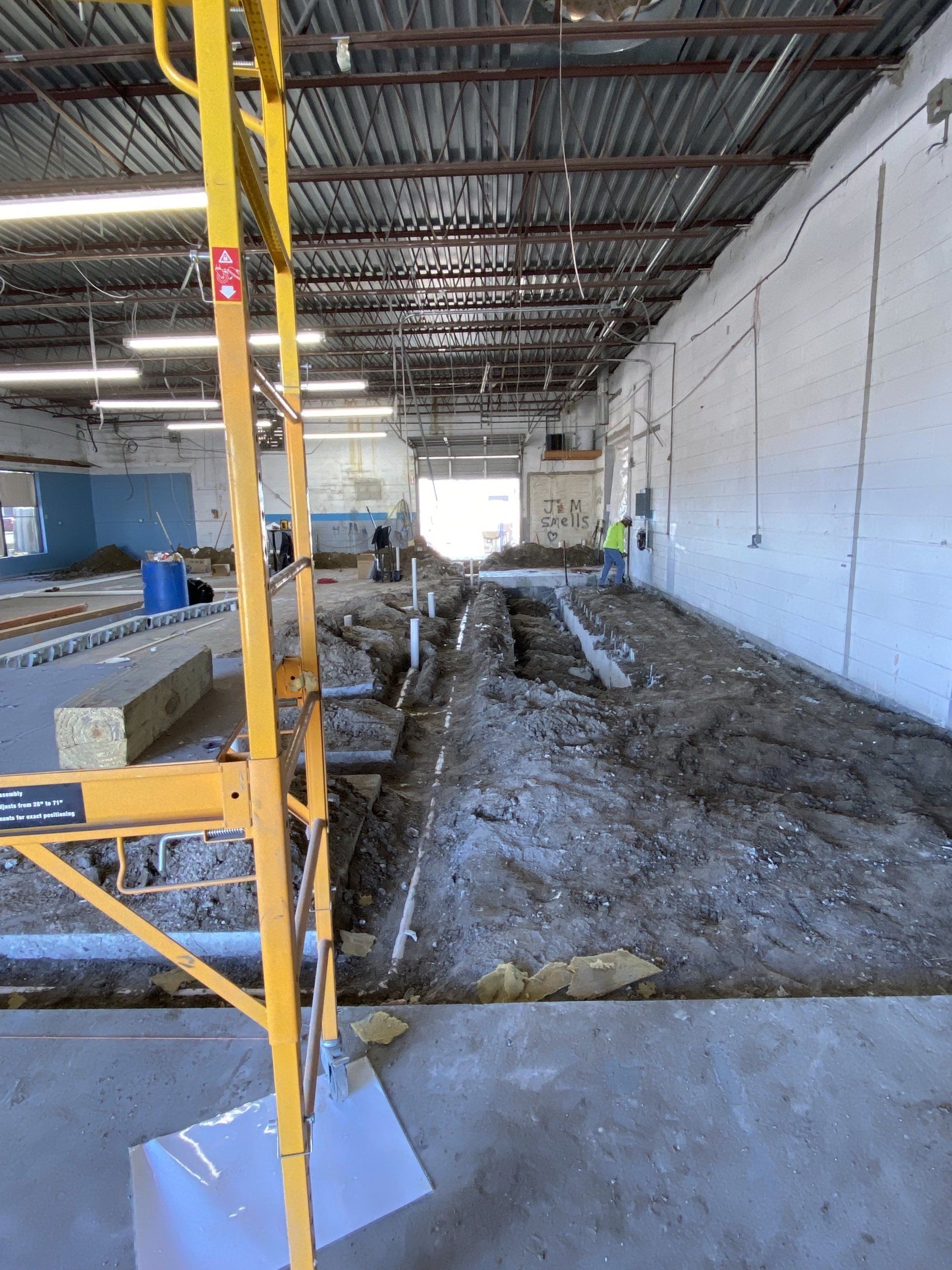 A large building with a lot of dirt and a shovel in the foreground.