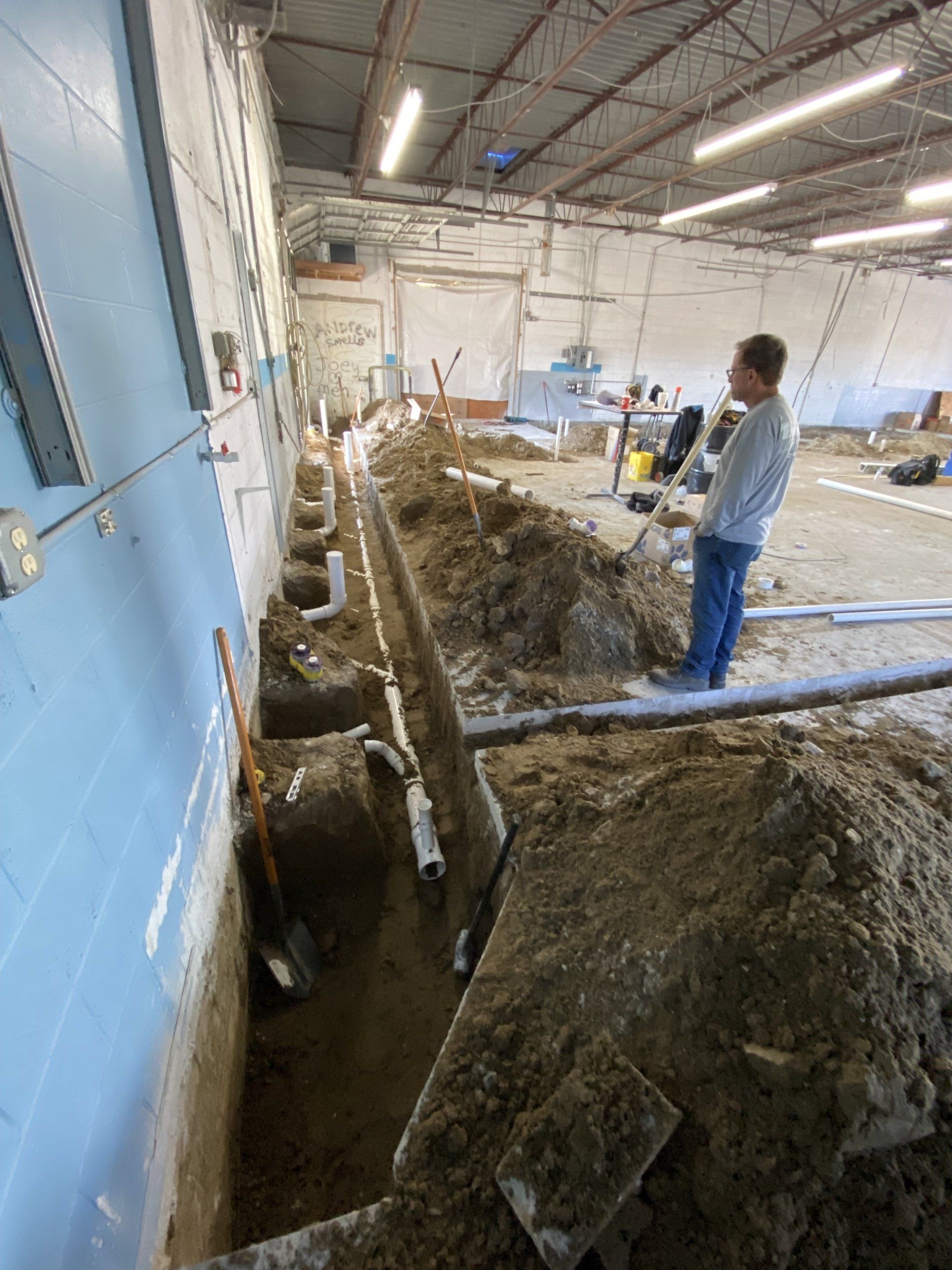 A man is standing in a pile of dirt in a building.