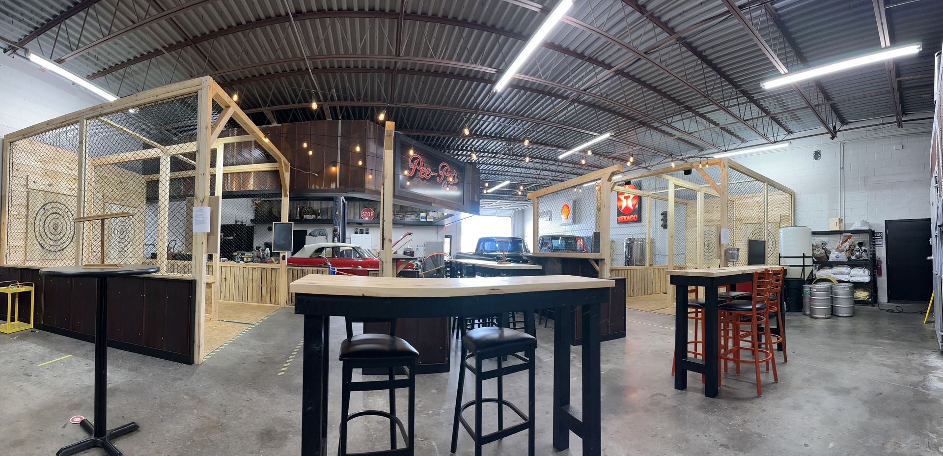 A large room with tables and stools in it.