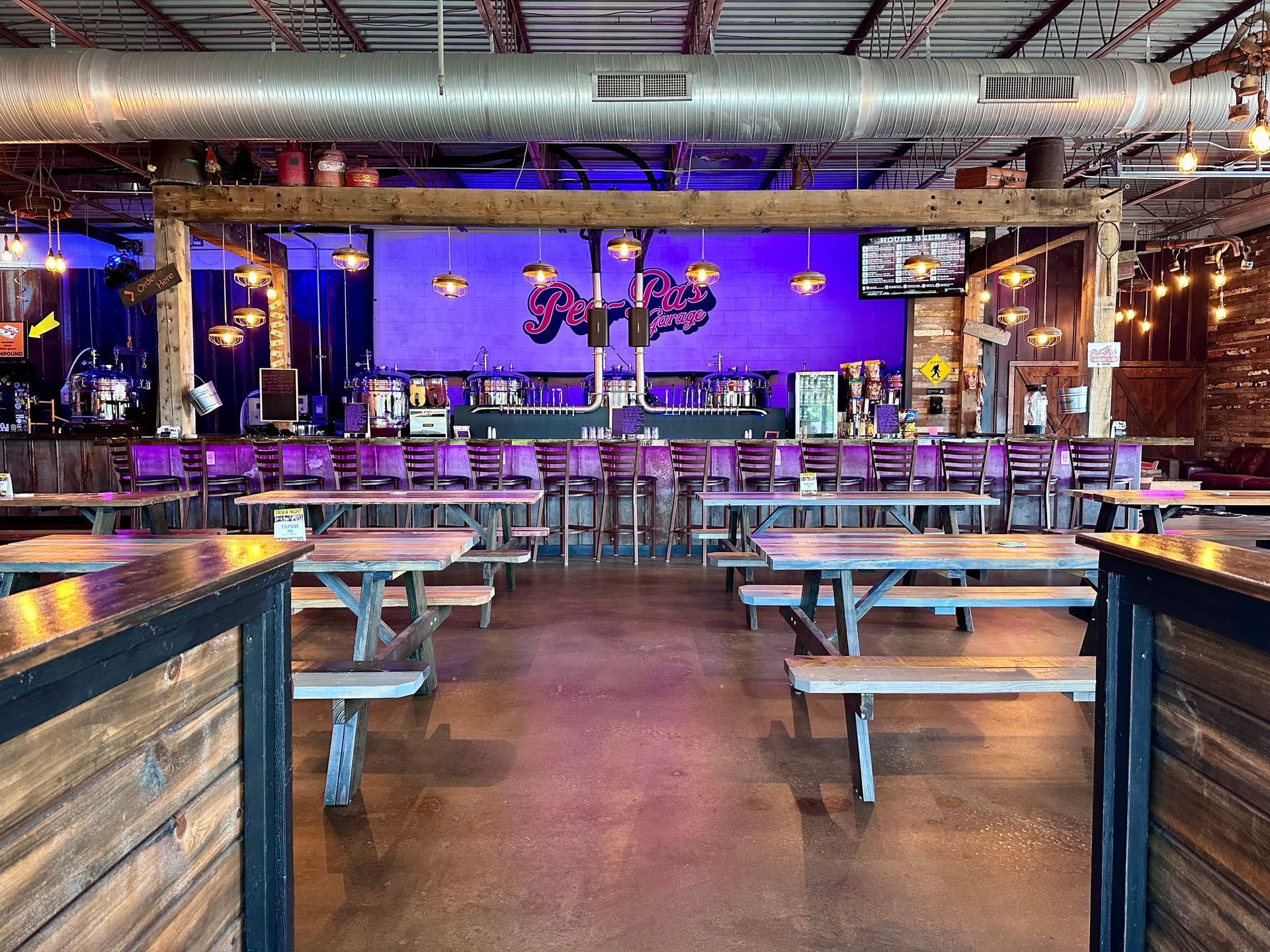 A restaurant with a lot of picnic tables and benches.
