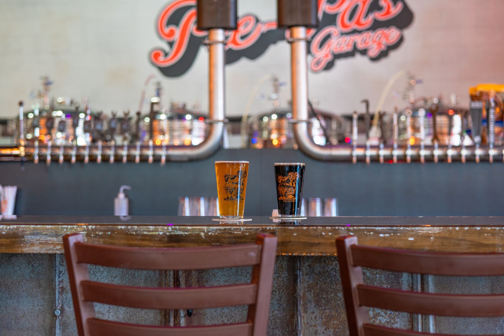 A long row of bar stools in a restaurant with purple lights.