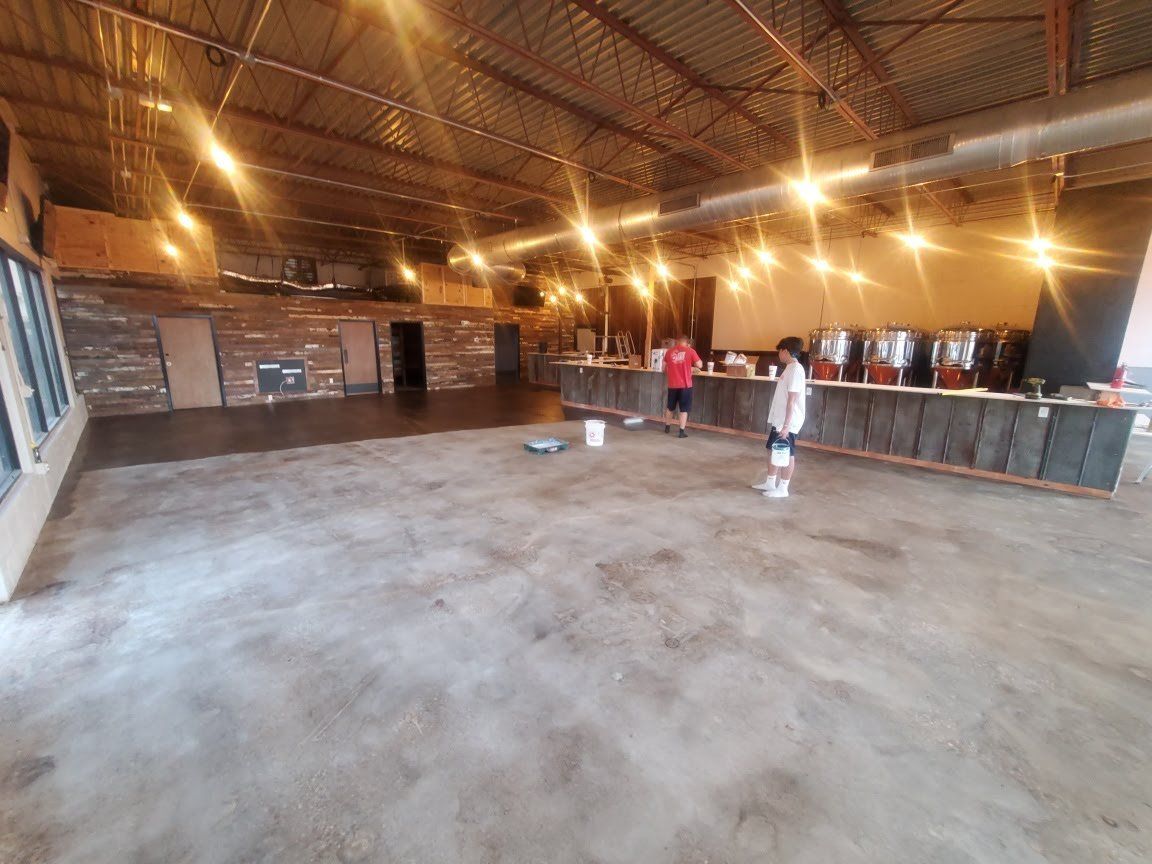 A man and a woman are standing in a large empty room.