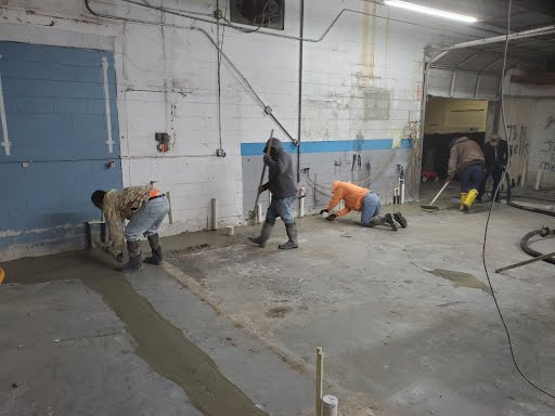 A group of men are working on the floor of a building.