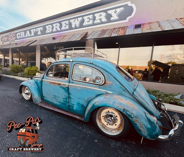 A blue car is parked in front of a craft brewery