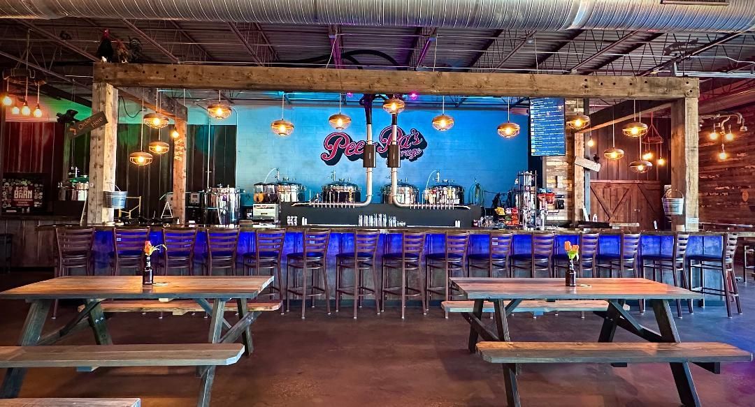 A restaurant with tables and benches and a bar.