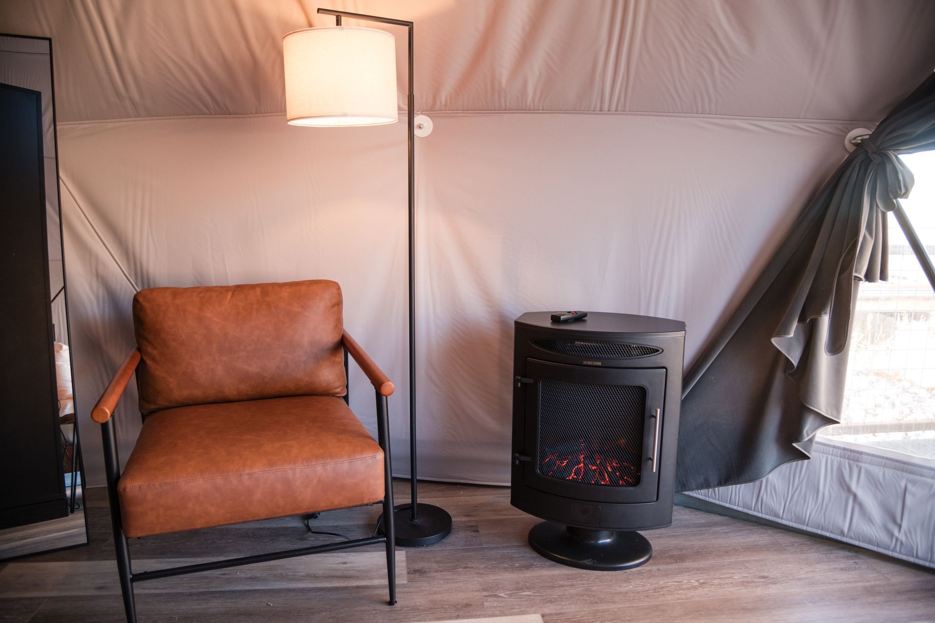 White geodesic dome structure on a platform, connected by a metal ramp, in a snowy outdoor setting.