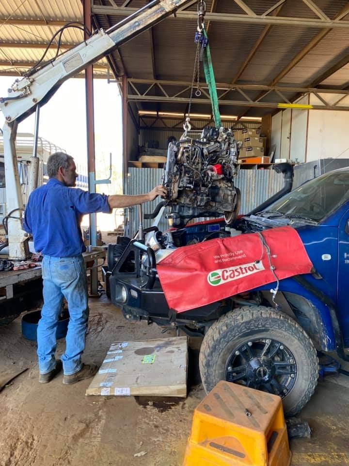 Man in Blue Shirt Guides an Engine Lifted — Traction Diesel Services in Clermont, QLD