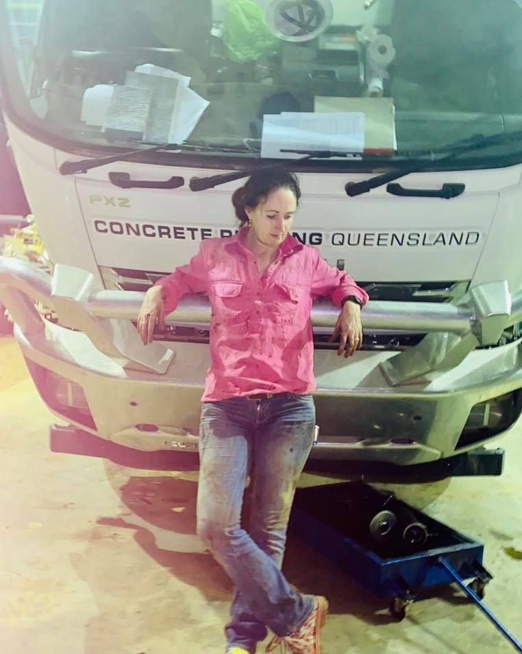 Woman in Pink Shirt and Jeans Leaning Against a Concrete Truck — Traction Diesel Services in Clermont, QLD