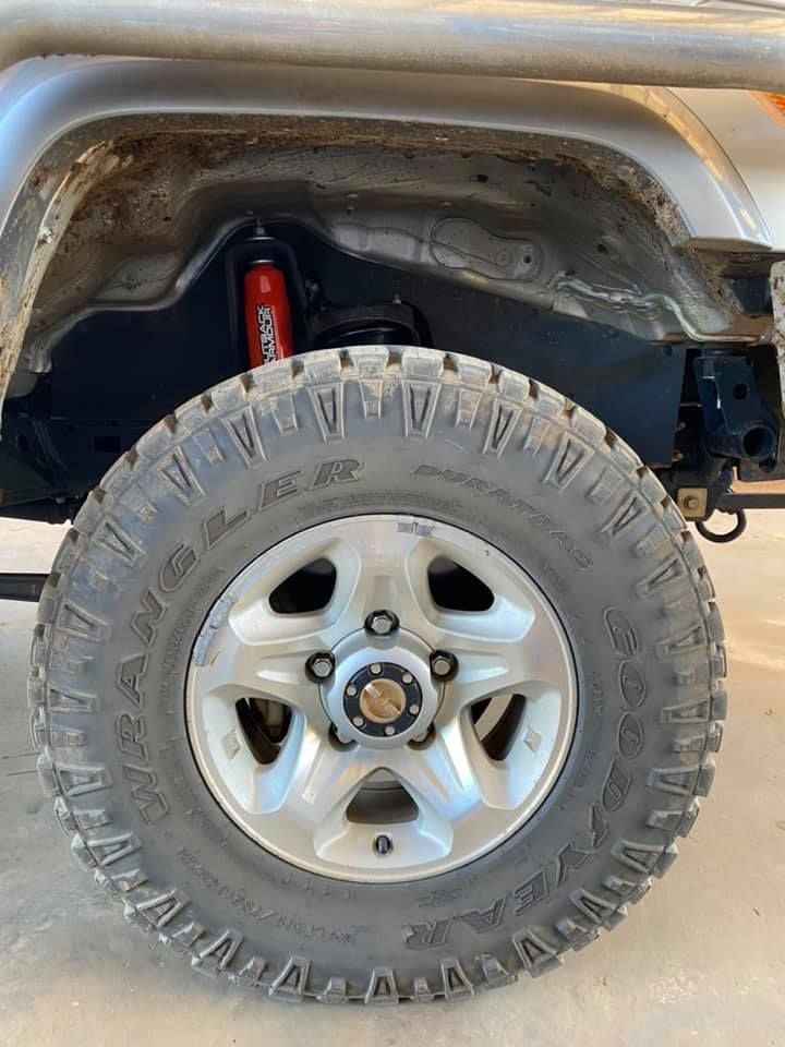 Off-road Vehicle Wheel With a Large Tire and a Red Shock Absorber Visible — Traction Diesel Services in Clermont, QLD
