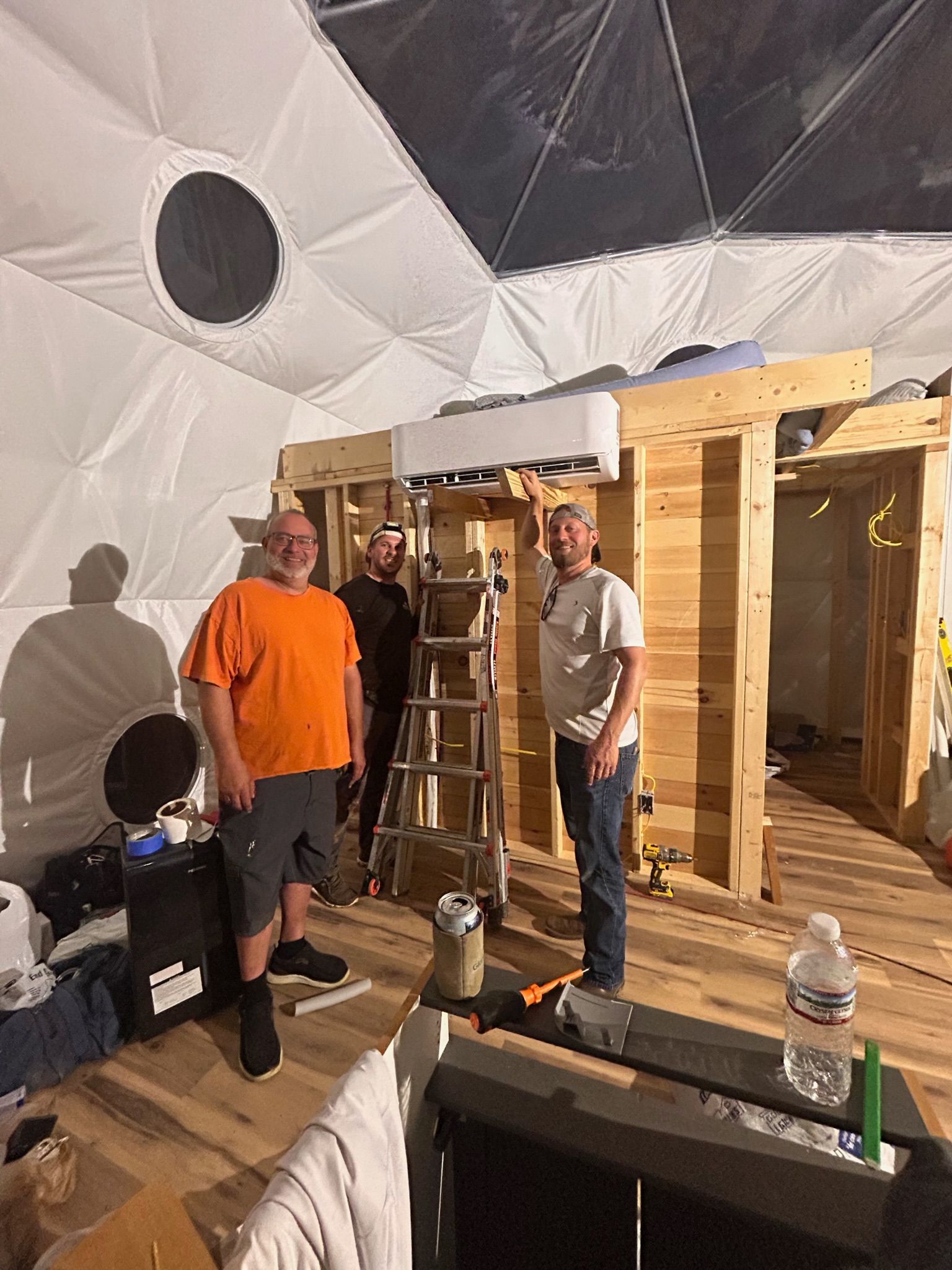 A group of men are standing in a room under construction.