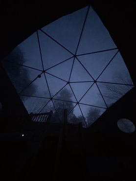 Looking up at the sky through a dome at night.