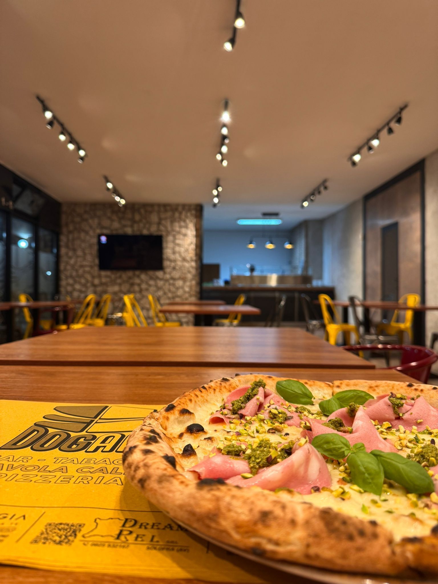 Una pizza è appoggiata su un tavolo in un ristorante.