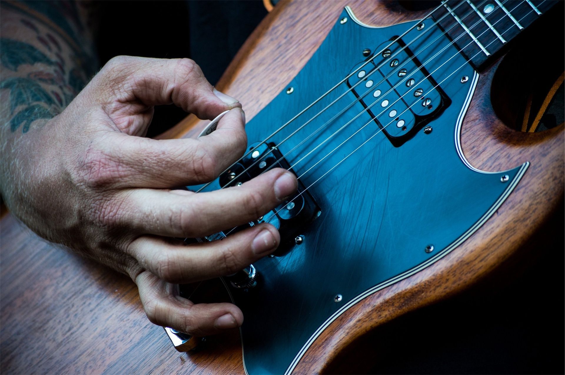 A close up of a person strumming an electric guitar