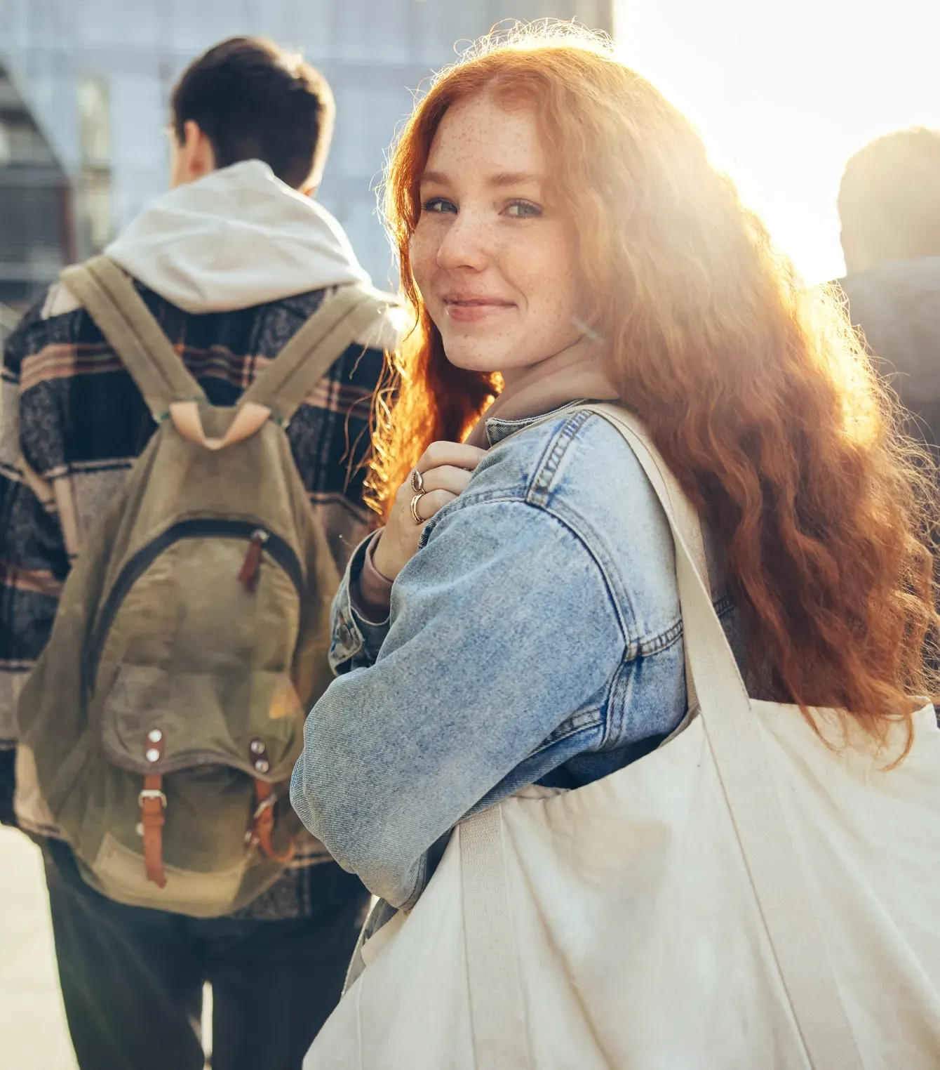 Una mujer pelirroja lleva una bolsa blanca