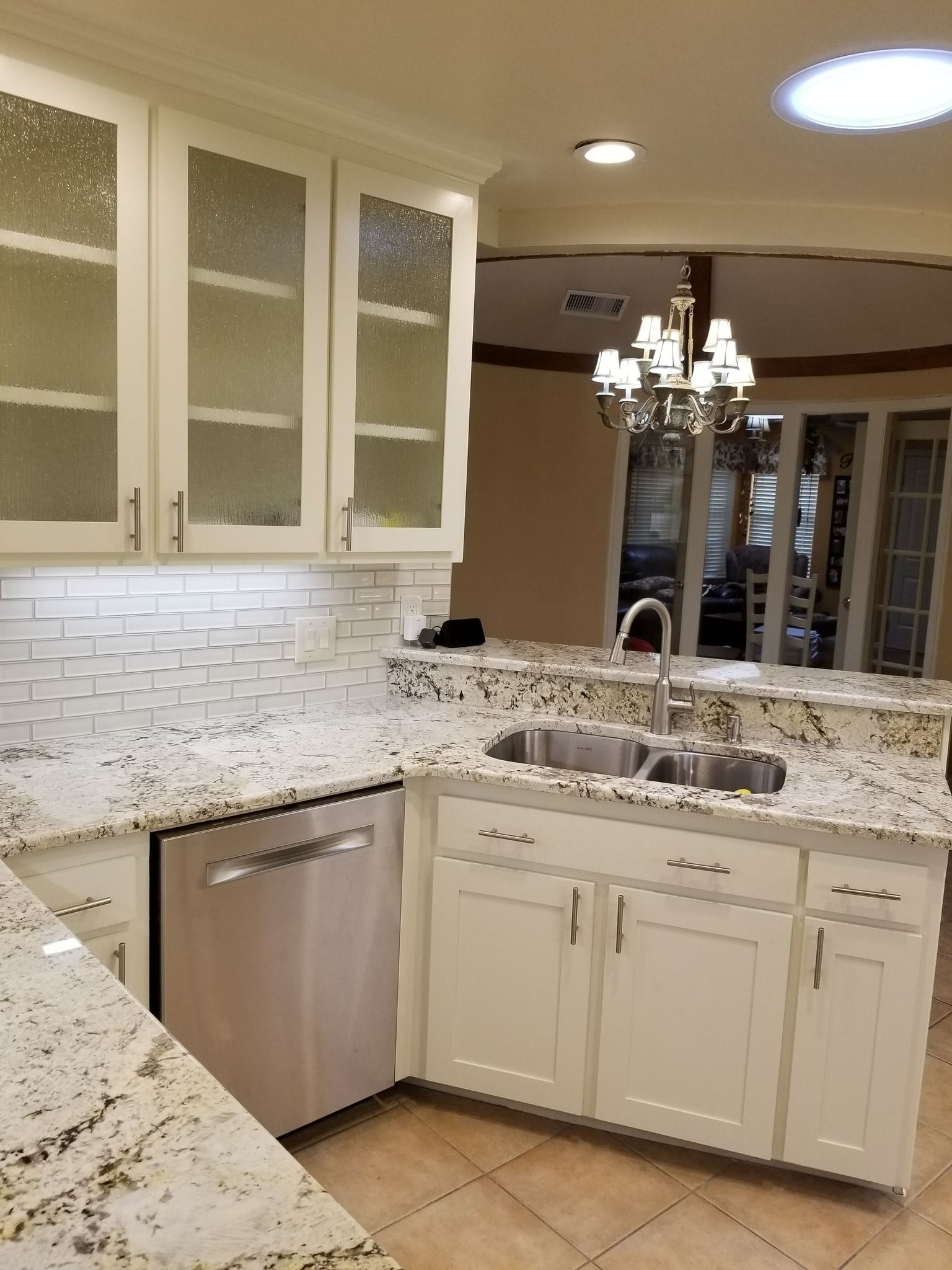 Kitchen with white cabinets, stainless steel appliances, granite countertops, and decorative tile backsplash.