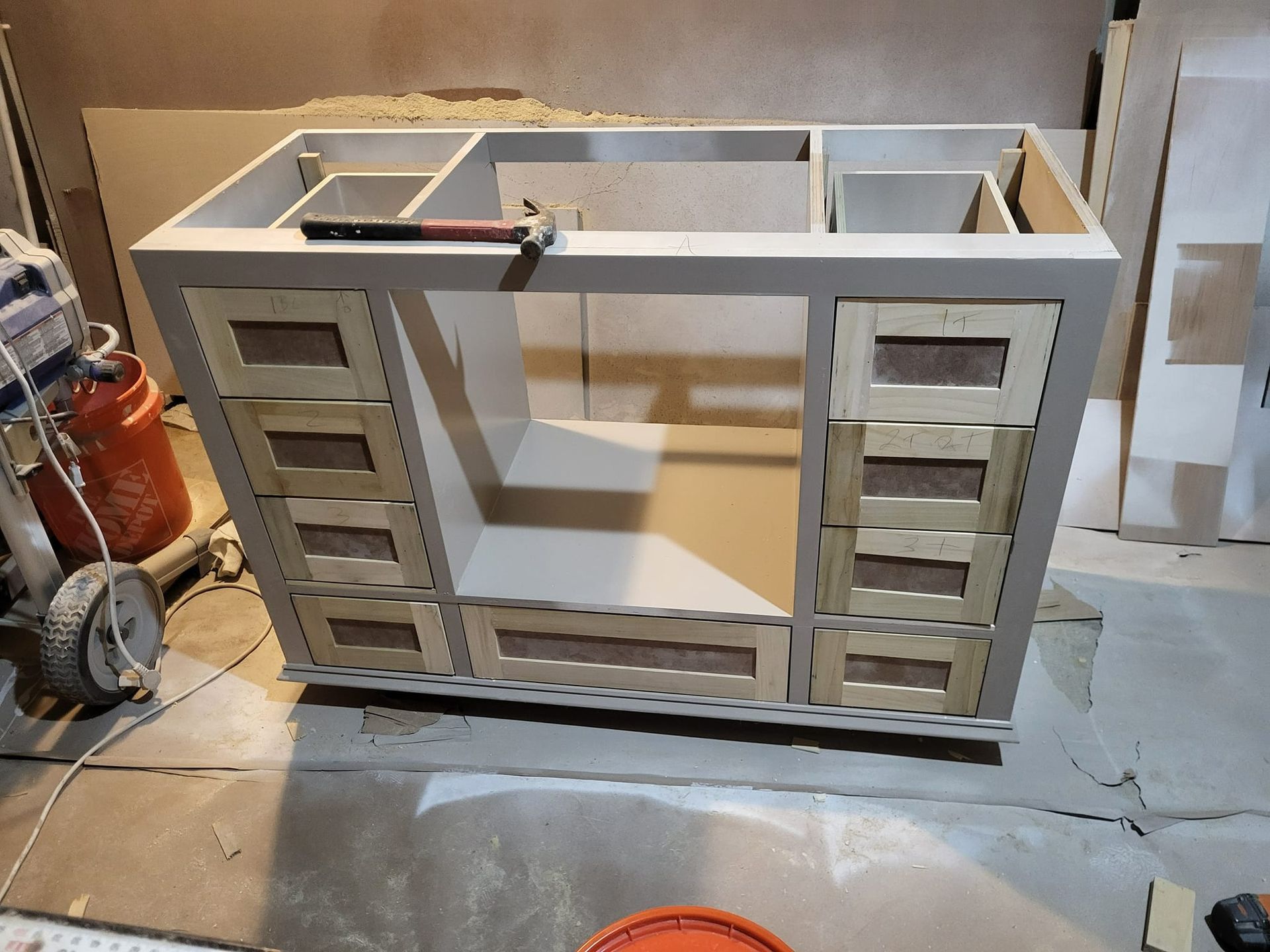A partially built bathroom vanity in a workshop, with unfinished drawer fronts.