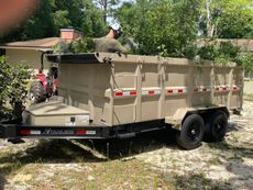A man is standing in the back of a dumpster trailer.