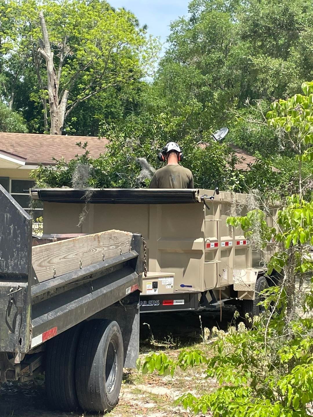 A man is sitting on top of a dump truck.