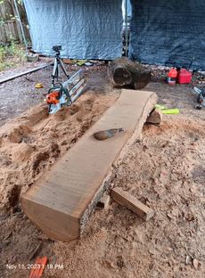 A large piece of wood is being cut with a chainsaw.