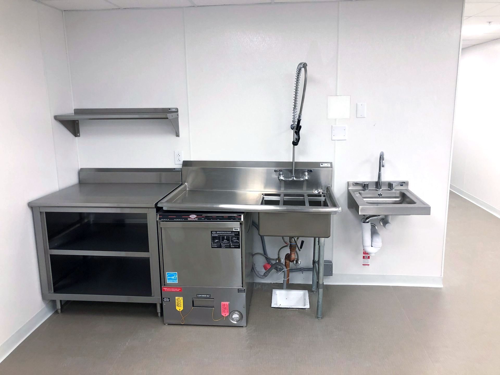 a stainless steel kitchen with a dishwasher and a sink